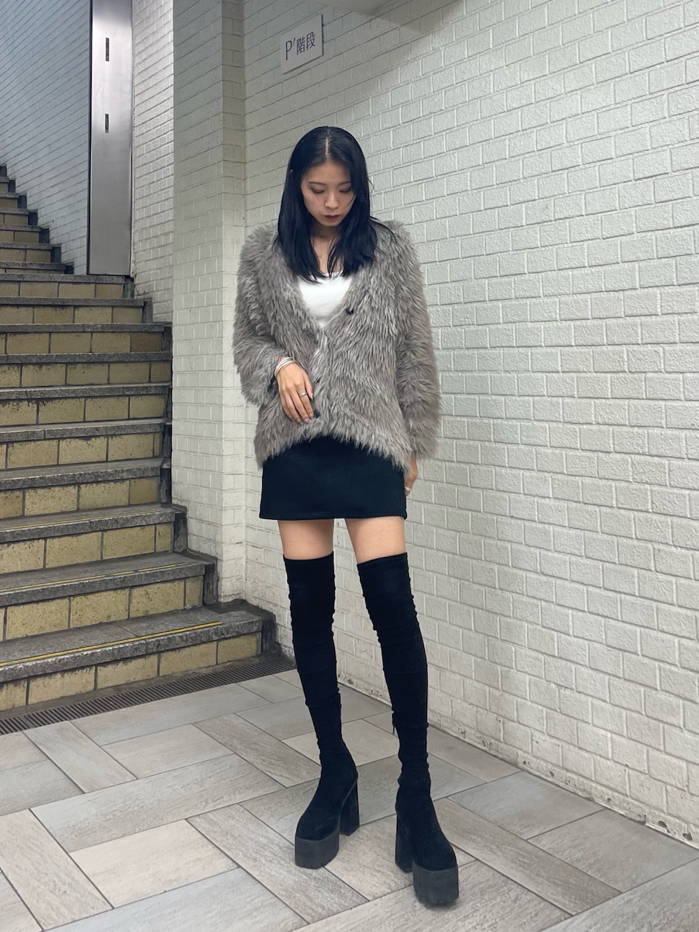 グレー系のカーディガン/ボレロ、ホワイト系のTシャツ/カットソー、ブラック系のスカートを着用したレディースの秋コーディネートの1枚目の写真