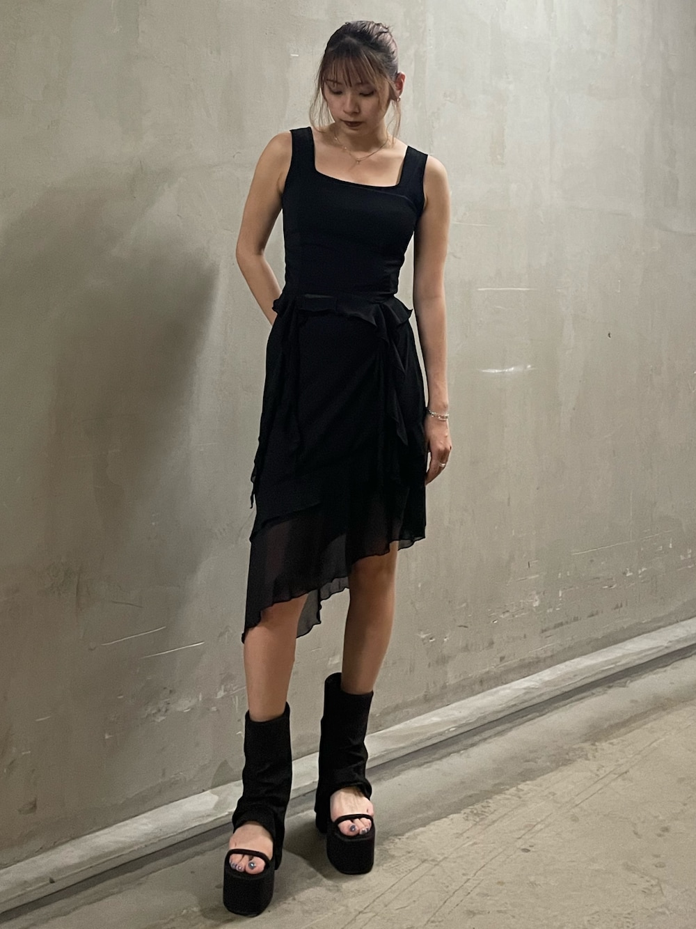 ブラック系のTシャツ/カットソー、ブラック系のニット/セーター、ブラック系のスカートを着用したレディースの春コーディネートの1枚目の写真