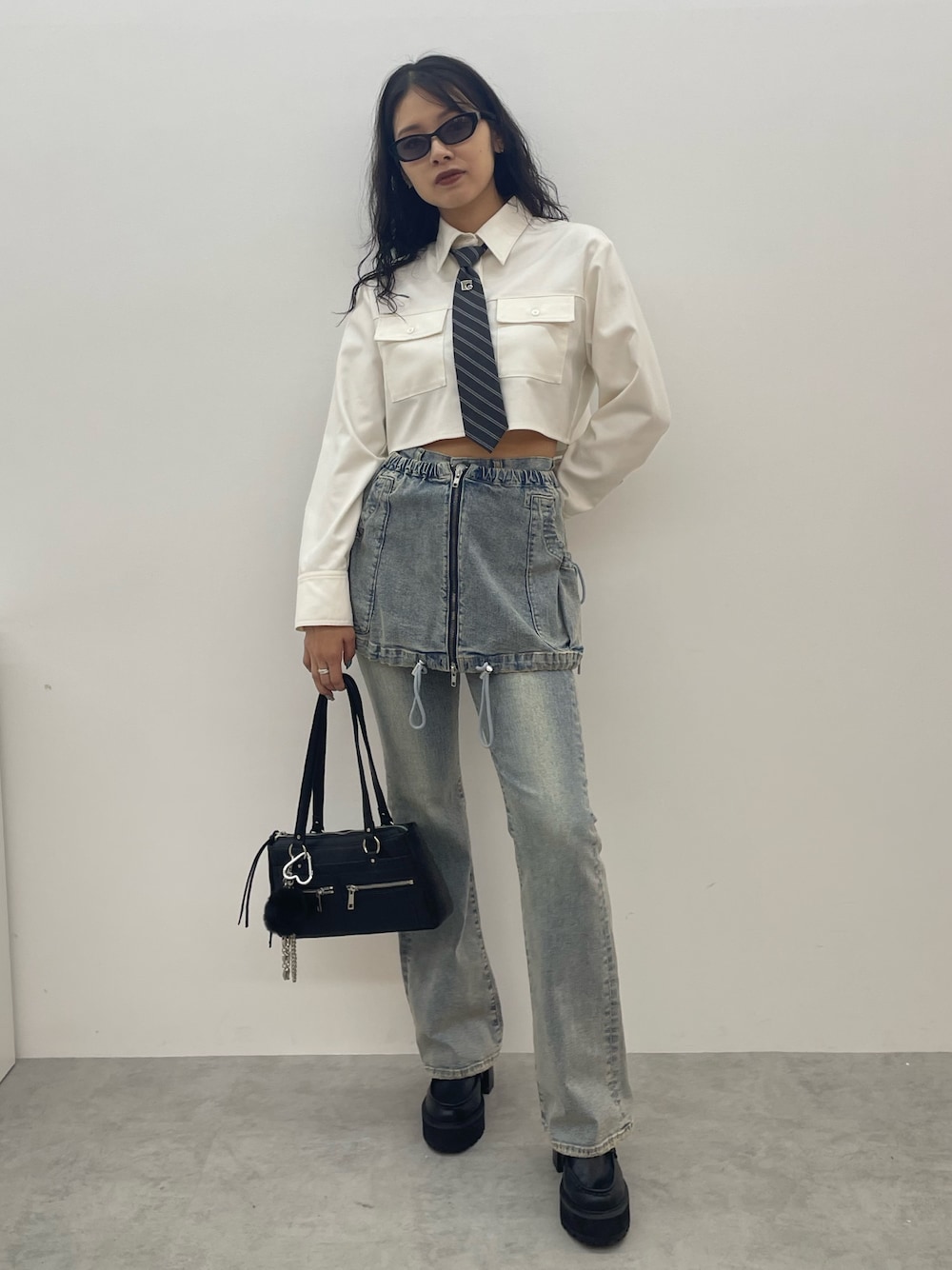 ホワイト系のシャツ/ブラウス、ブルー系のデニムパンツ、ブラック系のショルダーバッグを着用したレディースの夏コーディネートの1枚目の写真