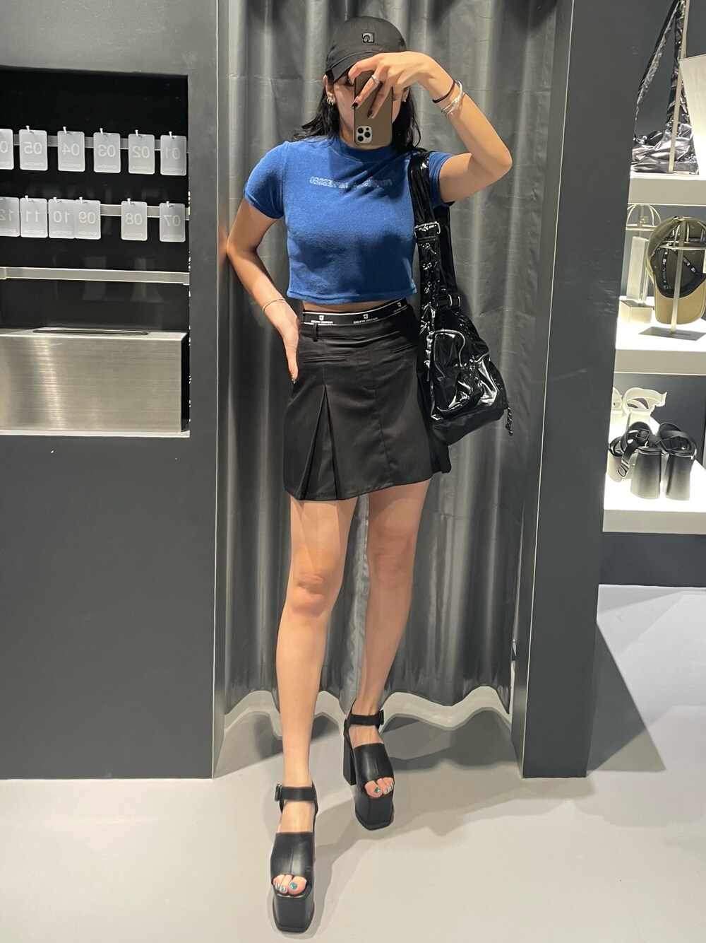 ブルー系のTシャツ/カットソー、ブラック系のハンドバッグ、ブラック系のスカートを着用したレディースの夏コーディネートの1枚目の写真