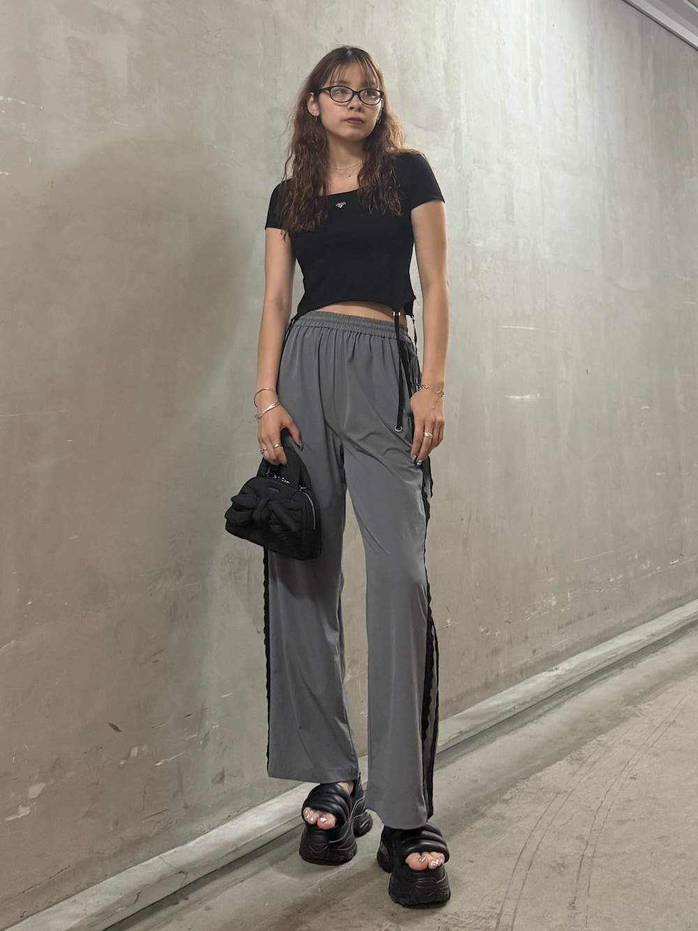 ブラック系のTシャツ/カットソー、グレー系のその他パンツ、ブラック系のハンドバッグを着用したレディースの夏コーディネートの1枚目の写真
