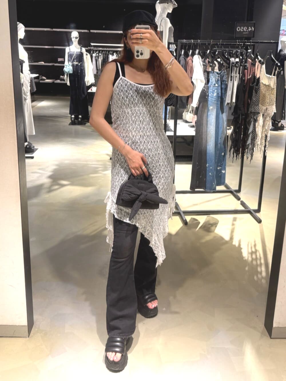 ブラック系のデニムパンツ、ブラック系のニット/セーター、ブラック系のサンダルを着用したレディースの夏コーディネートの1枚目の写真