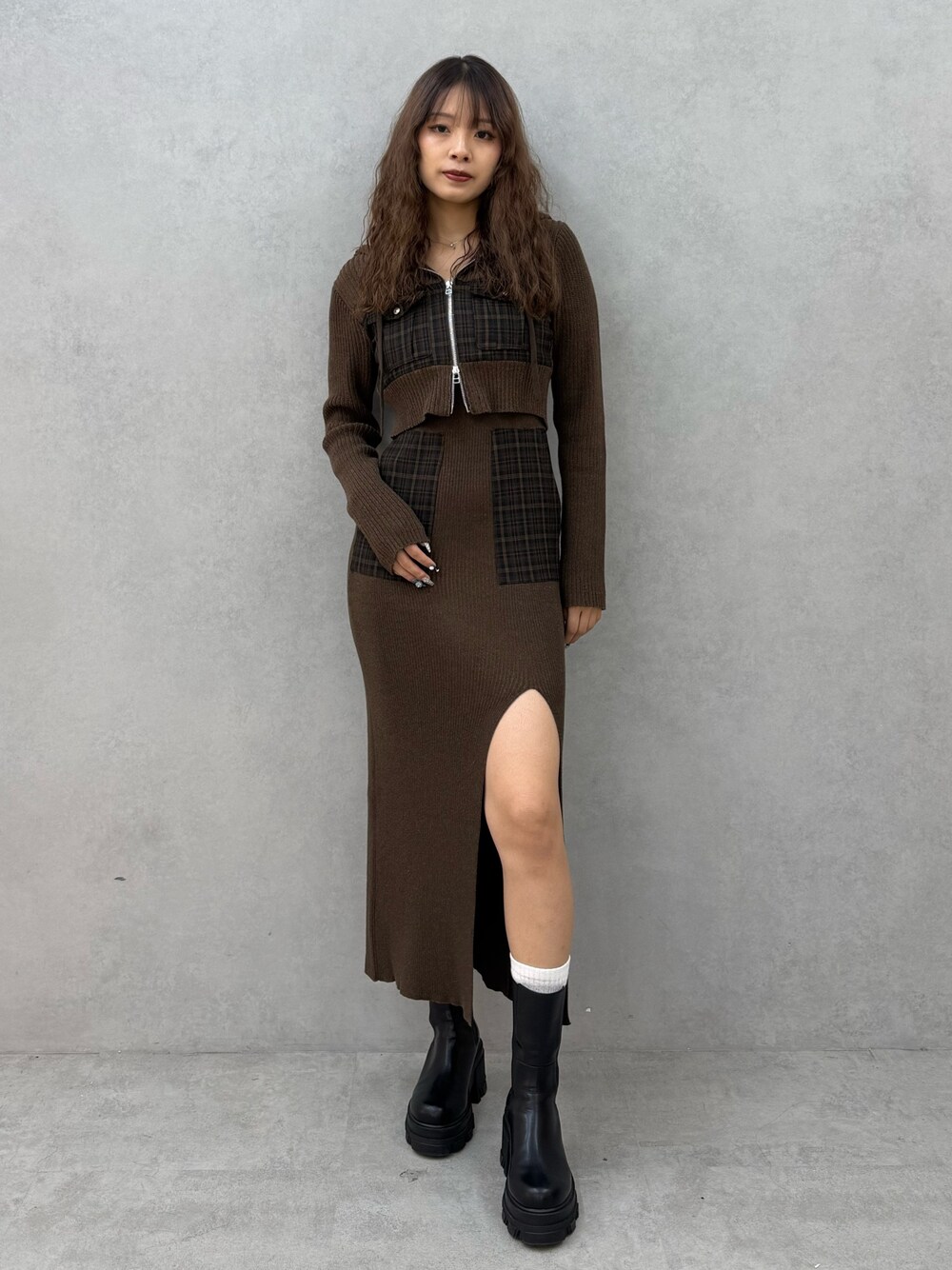 グリーン系のニット/セーター、グリーン系のワンピース、ブラック系のブーツを着用したレディースの秋コーディネートの1枚目の写真