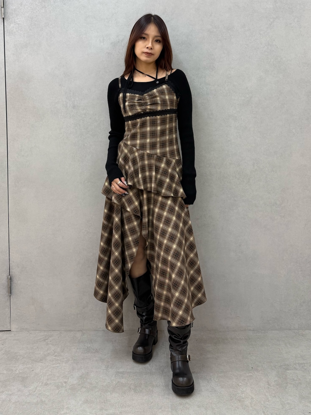 ブラック系のニット/セーター、ベージュ系のワンピース、ブラック系のブーツを着用したレディースの冬コーディネートの1枚目の写真