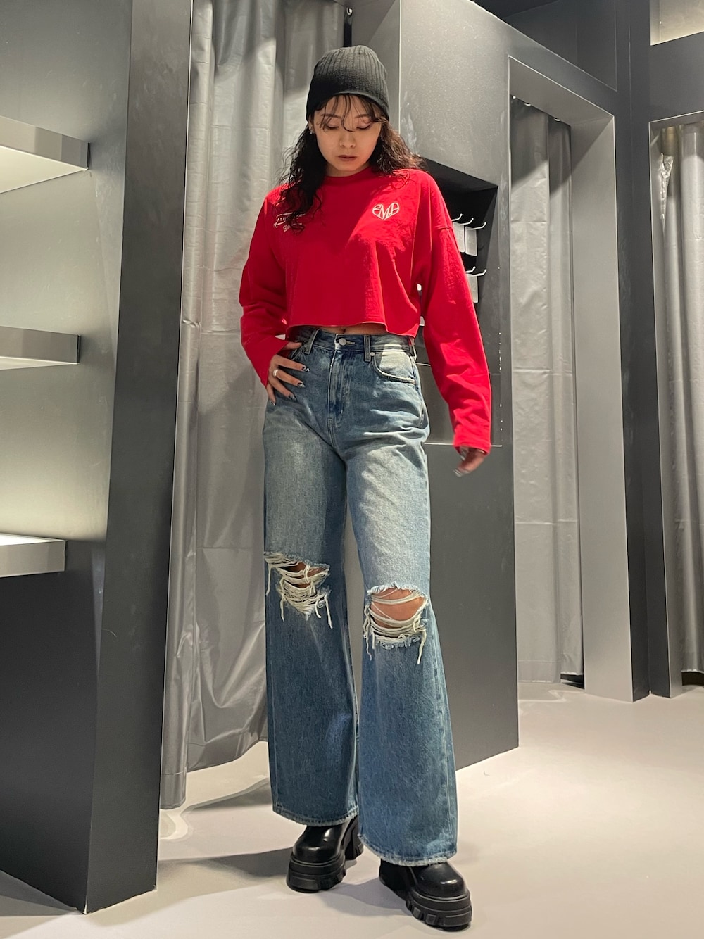 レッド系のTシャツ/カットソー、ブルー系のデニムパンツ、ブラック系のブーツを着用したレディースの秋コーディネートの1枚目の写真