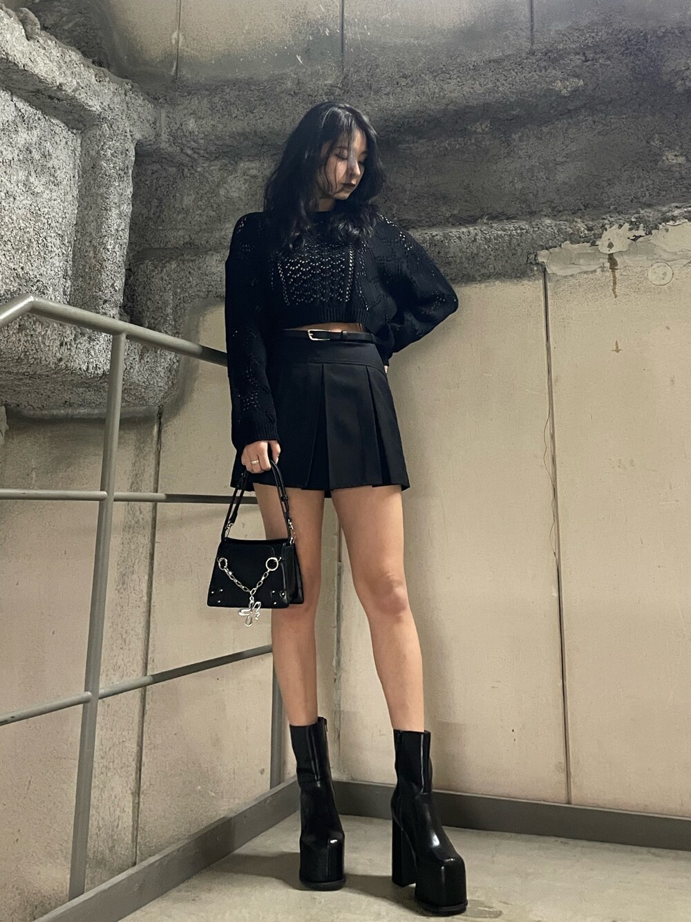 ブラック系のニット/セーター、ホワイト系のキャミソール、ブラック系のスカートを着用したレディースの春コーディネートの1枚目の写真