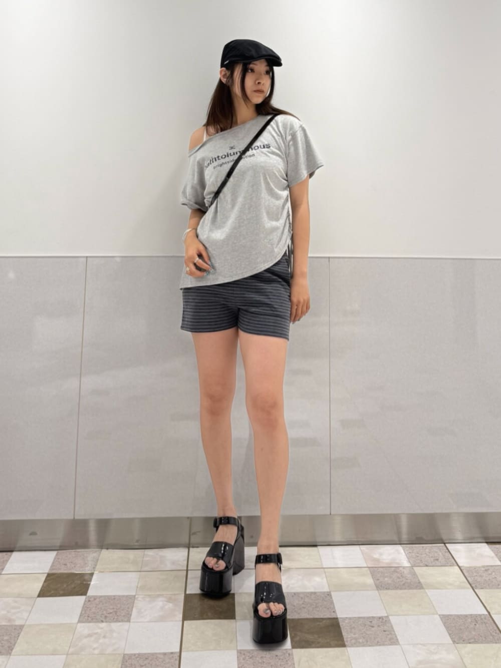 グレー系のTシャツ/カットソー、ブラック系のサンダル、ブラック系のハンドバッグを着用したレディースの夏コーディネートの1枚目の写真