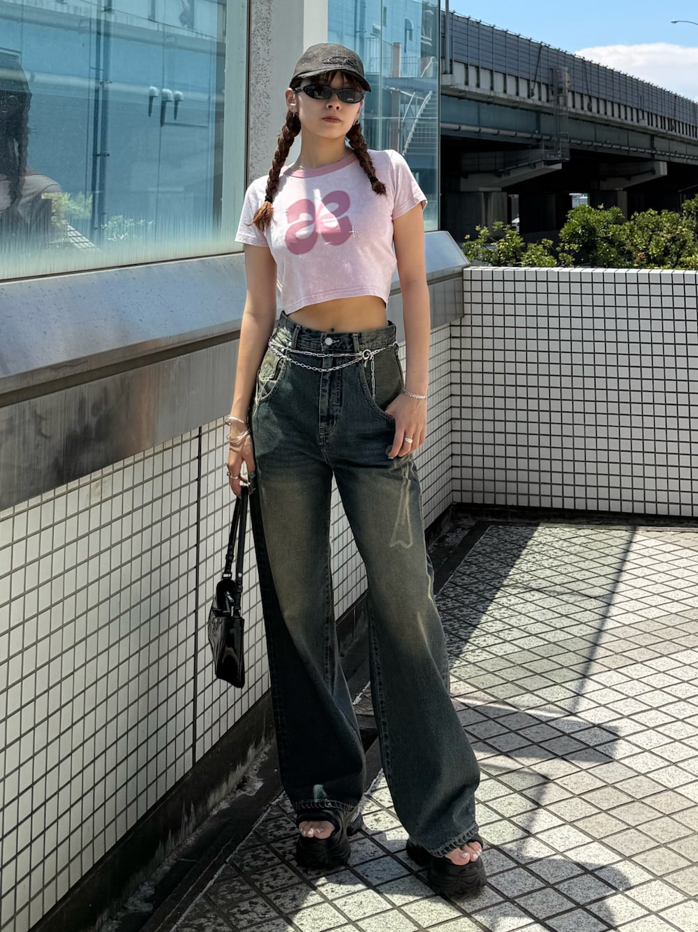 ピンク系のTシャツ/カットソー、ブルー系のデニムパンツ、ブラック系のショルダーバッグを着用したレディースの夏コーディネートの1枚目の写真