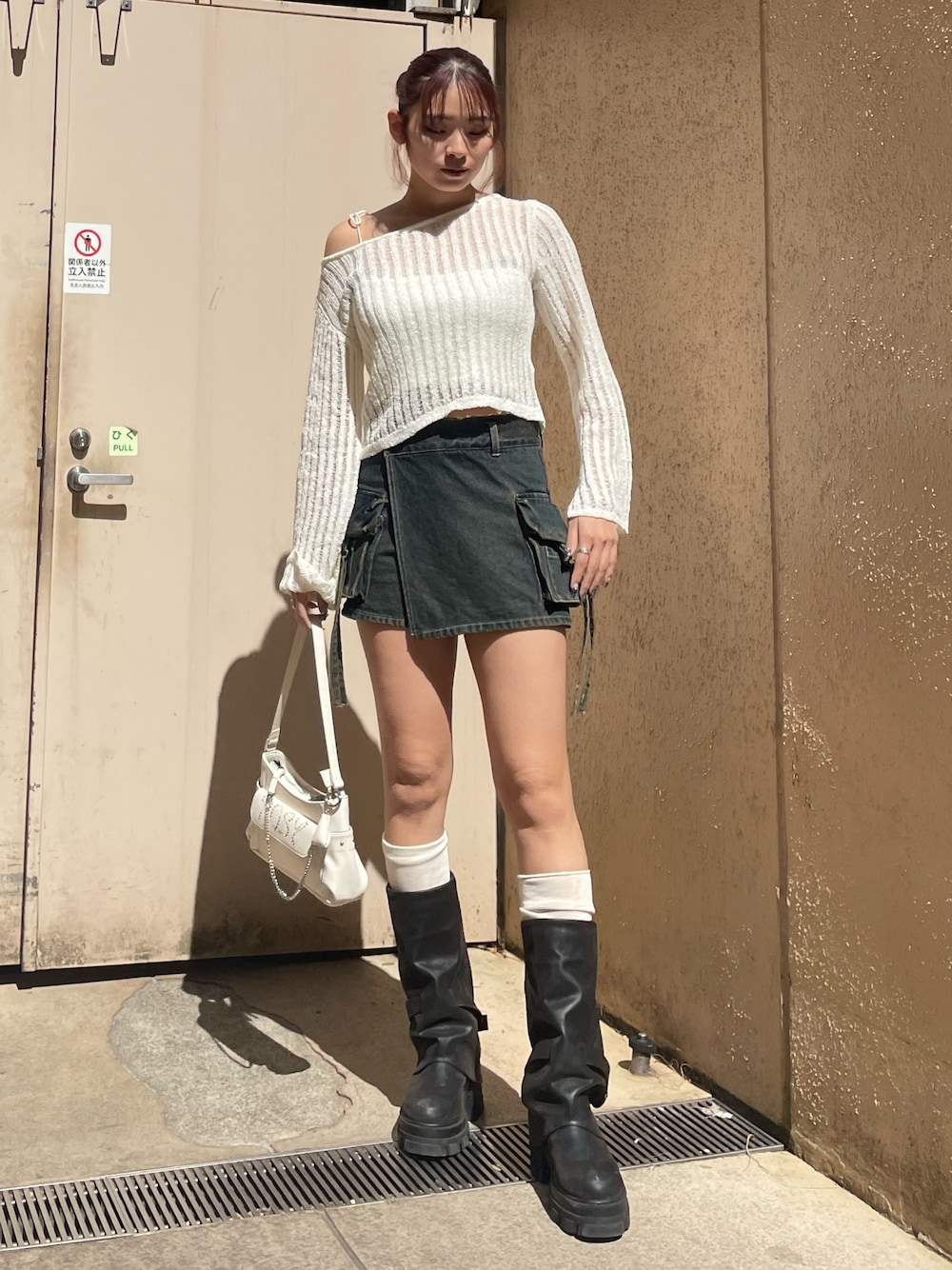 ホワイト系のニット/セーター、ブルー系のその他パンツ、ホワイト系のハンドバッグを着用したレディースの春コーディネートの1枚目の写真