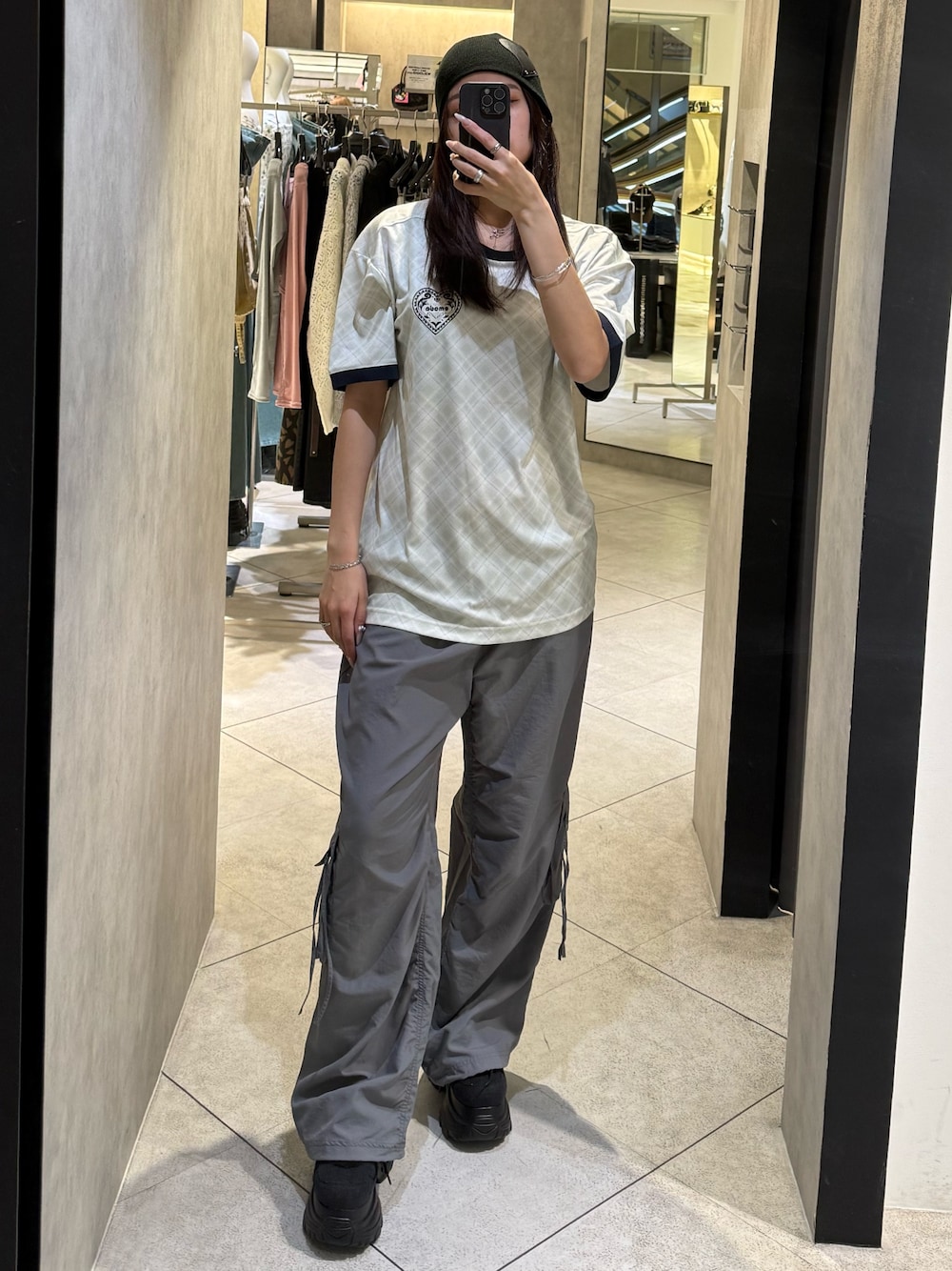 ホワイト系のTシャツ/カットソー、グレー系のその他パンツ、ブラック系のスニーカーを着用したレディースの春コーディネートの1枚目の写真