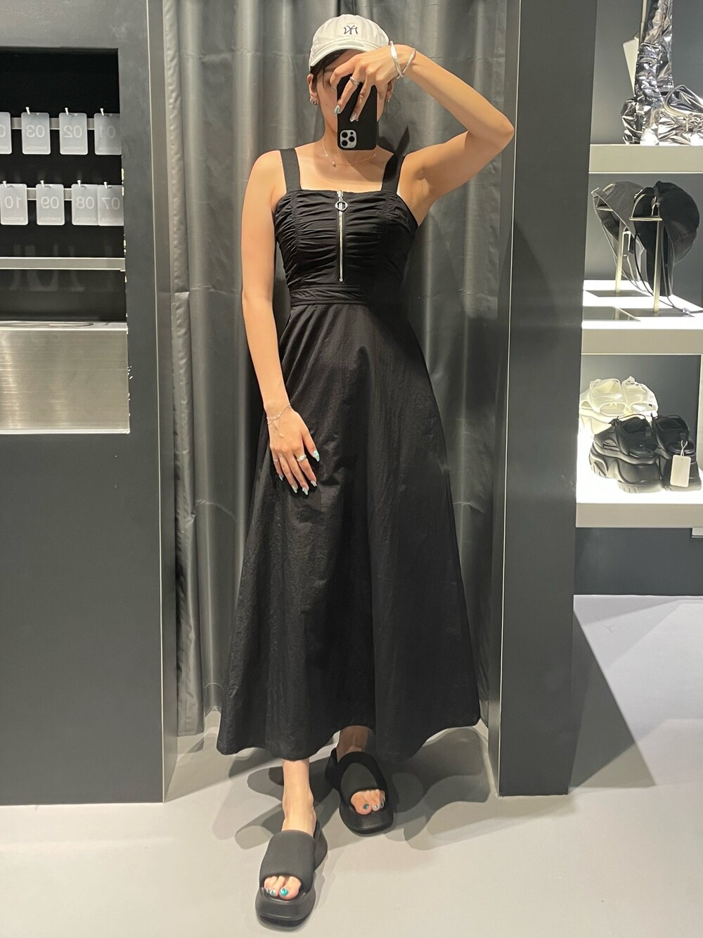 ブラック系のワンピース、ブラック系のサンダル、シルバー系のネックレスを着用したレディースの夏コーディネートの1枚目の写真