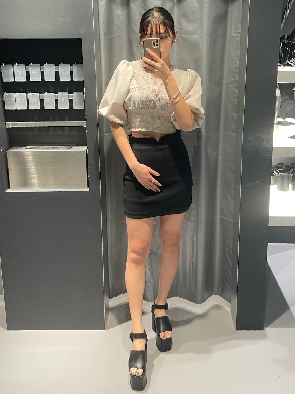 ベージュ系のTシャツ/カットソー、ブラック系のスカート、ブラック系のサンダルを着用したレディースの夏コーディネートの1枚目の写真