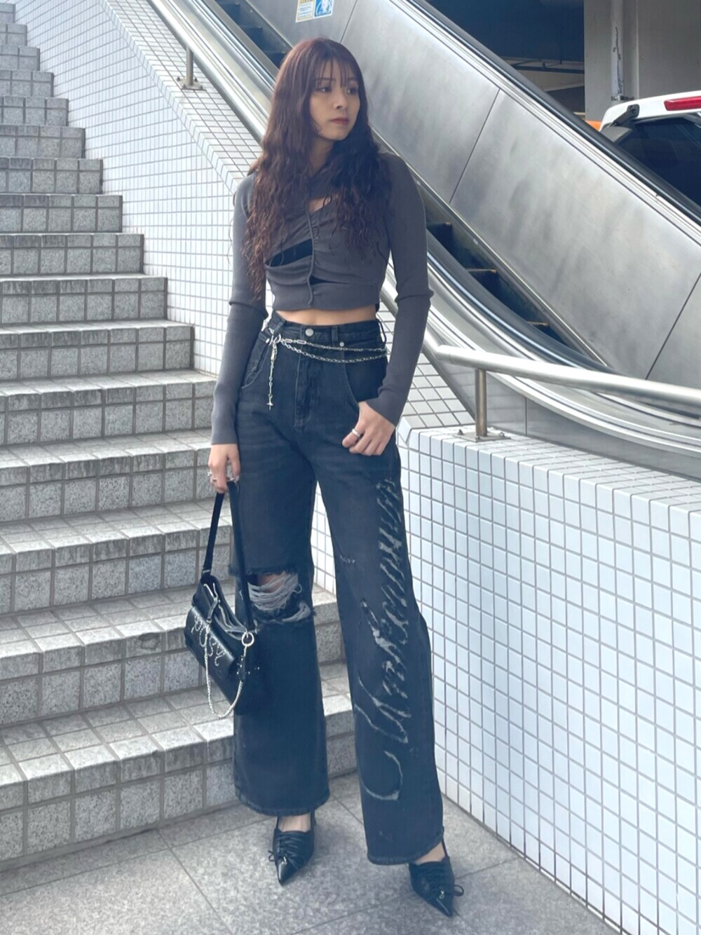 ブラック系のデニムパンツ、ブラック系のハンドバッグ、ブラック系のパンプスを着用したレディースの春コーディネートの1枚目の写真