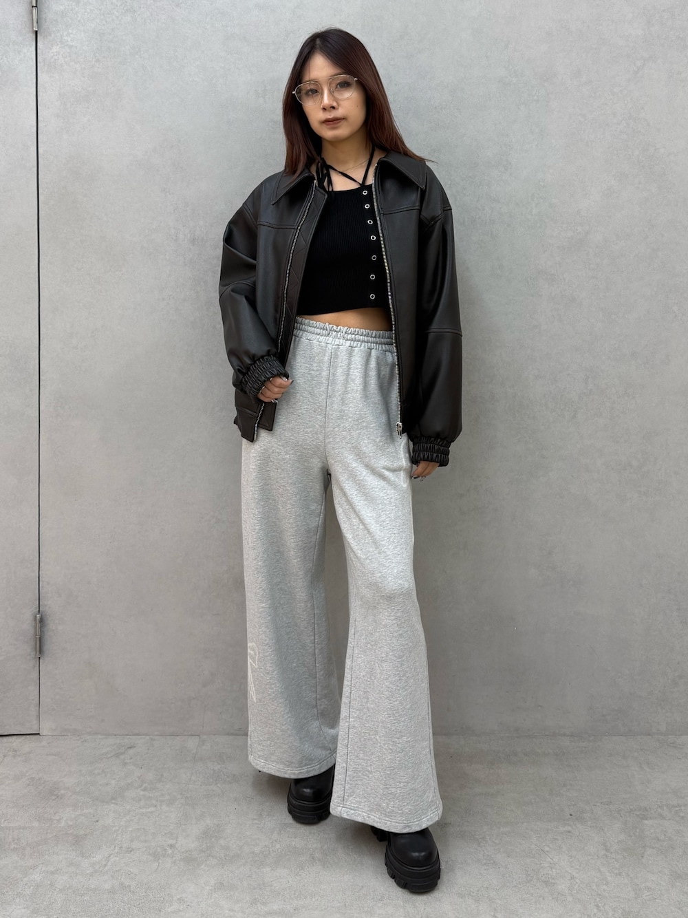 ブラック系のブルゾン、ブラック系のニット/セーター、グレー系のスウェットパンツを着用したレディースの冬コーディネートの1枚目の写真