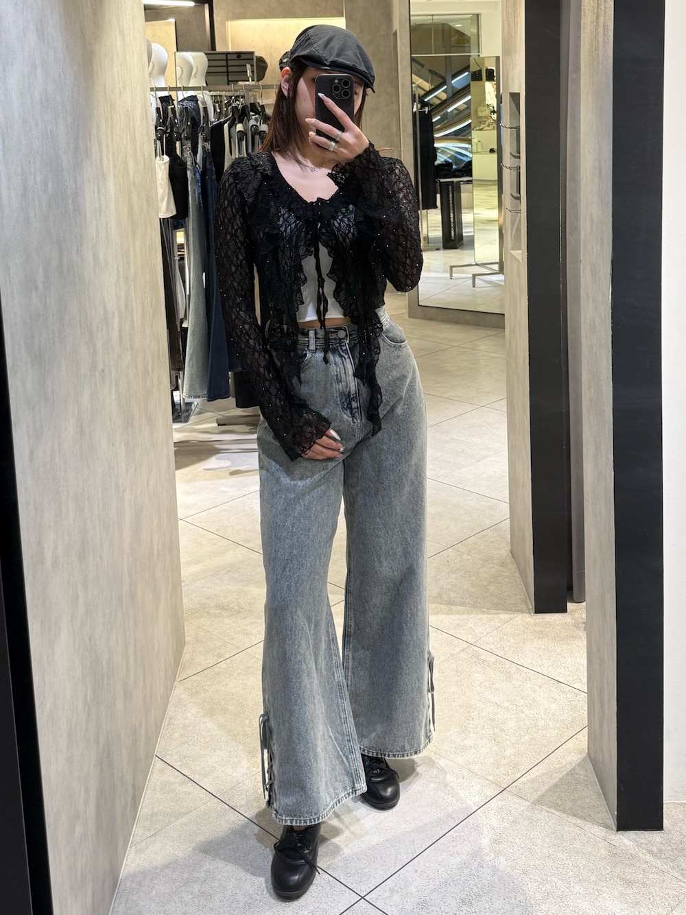 ブラック系のTシャツ/カットソー、ホワイト系のニット/セーター、ブルー系のデニムパンツを着用したレディースの春コーディネートの1枚目の写真