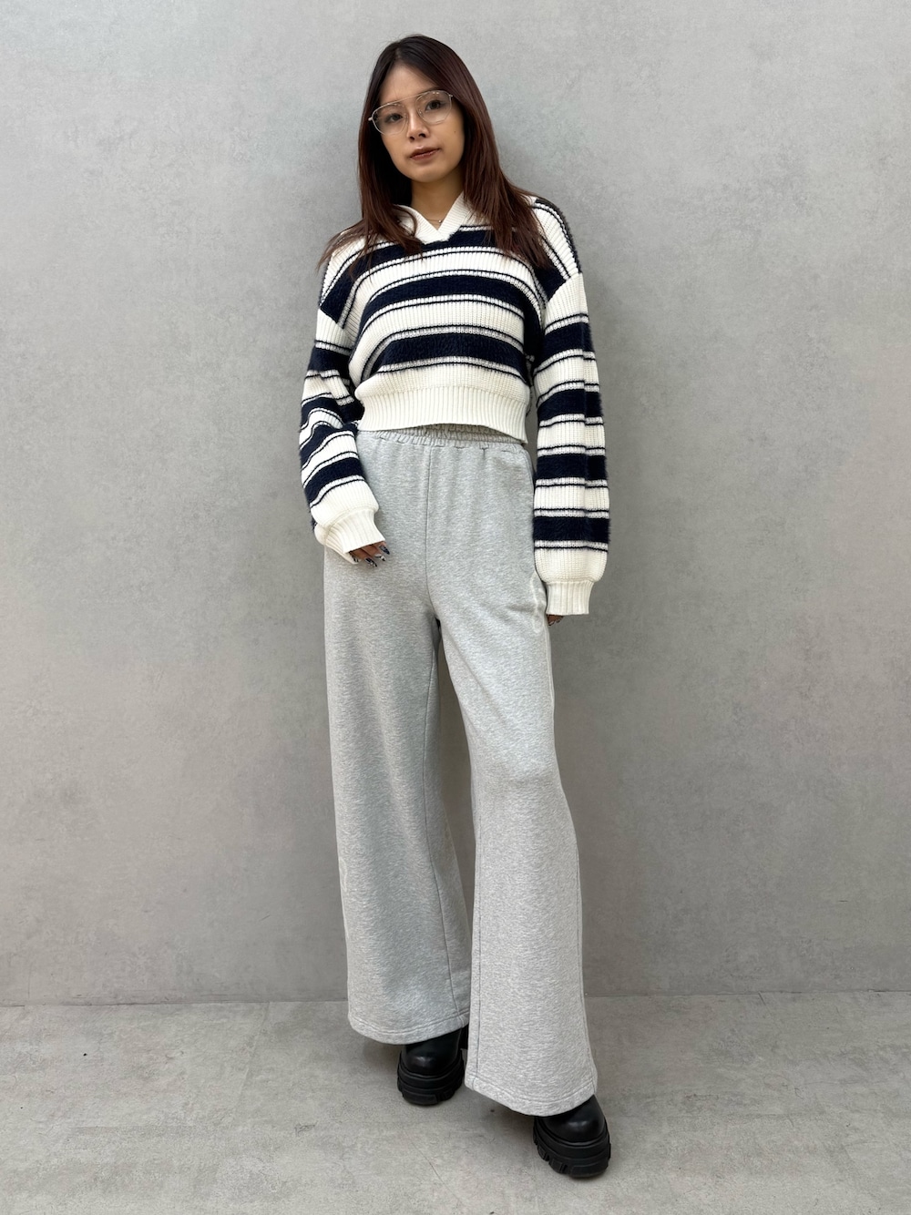 ブルー系のニット/セーター、グレー系のスウェットパンツ、ブラック系のブーツを着用したレディースの冬コーディネートの1枚目の写真