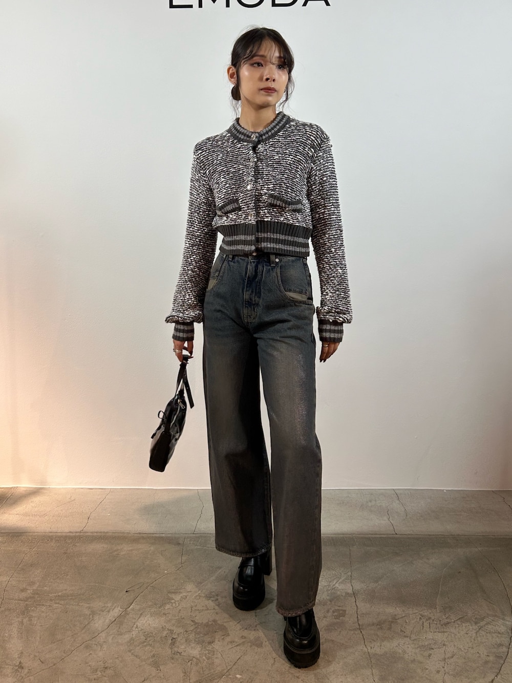 グレー系のカーディガン/ボレロ、ブルー系のデニムパンツ、ブラック系のショルダーバッグを着用したレディースの秋コーディネートの1枚目の写真