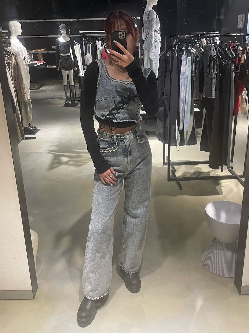 ブラック系のTシャツ/カットソー、ブルー系のデニムパンツ、ブラック系のブーツを着用したレディースの春コーディネートの1枚目の写真