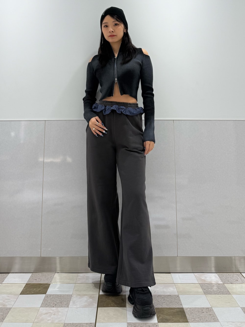 ブラック系のニット/セーター、グレー系のスウェットパンツ、ブラック系のスニーカーを着用したレディースの冬コーディネートの1枚目の写真