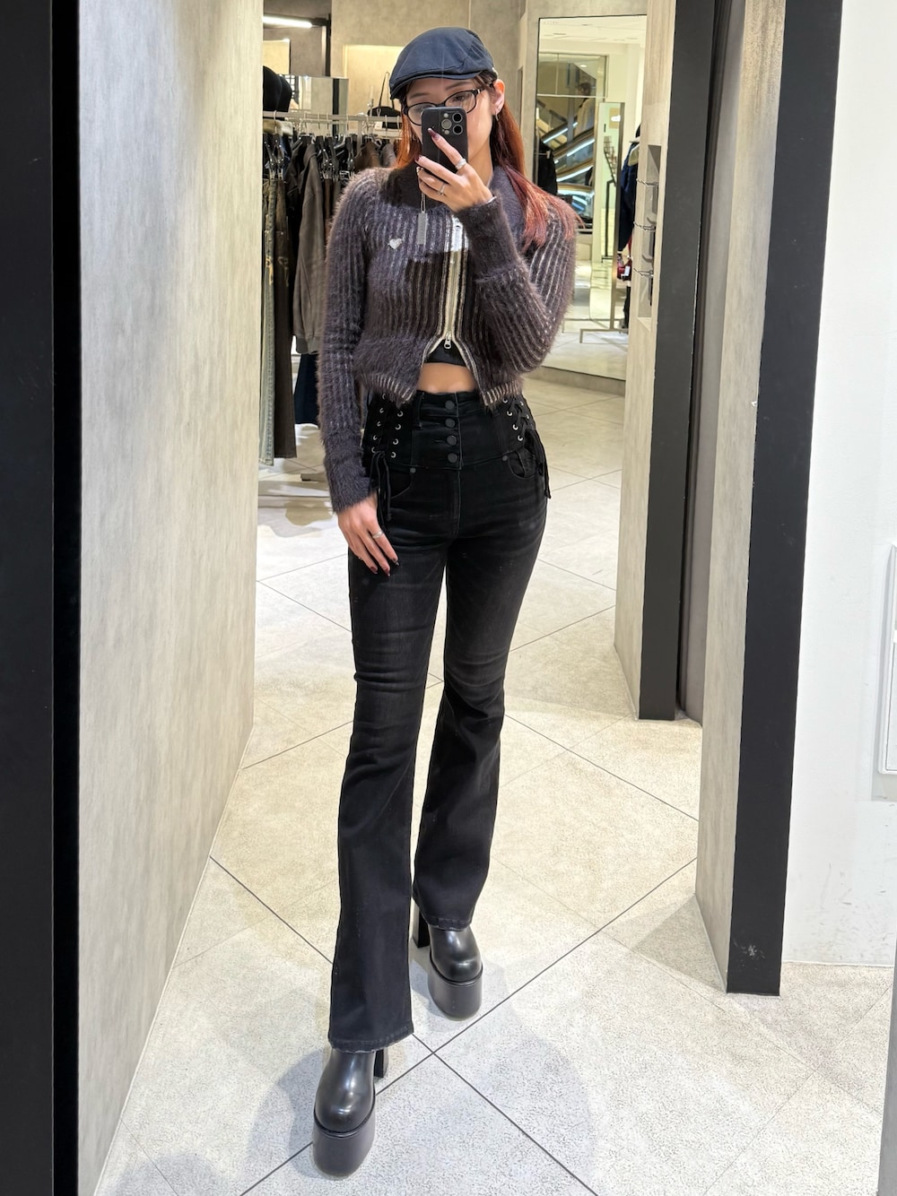 ブラウン系のニット/セーター、ブラック系のデニムパンツ、ブラック系のブーツを着用したレディースの秋コーディネートの1枚目の写真