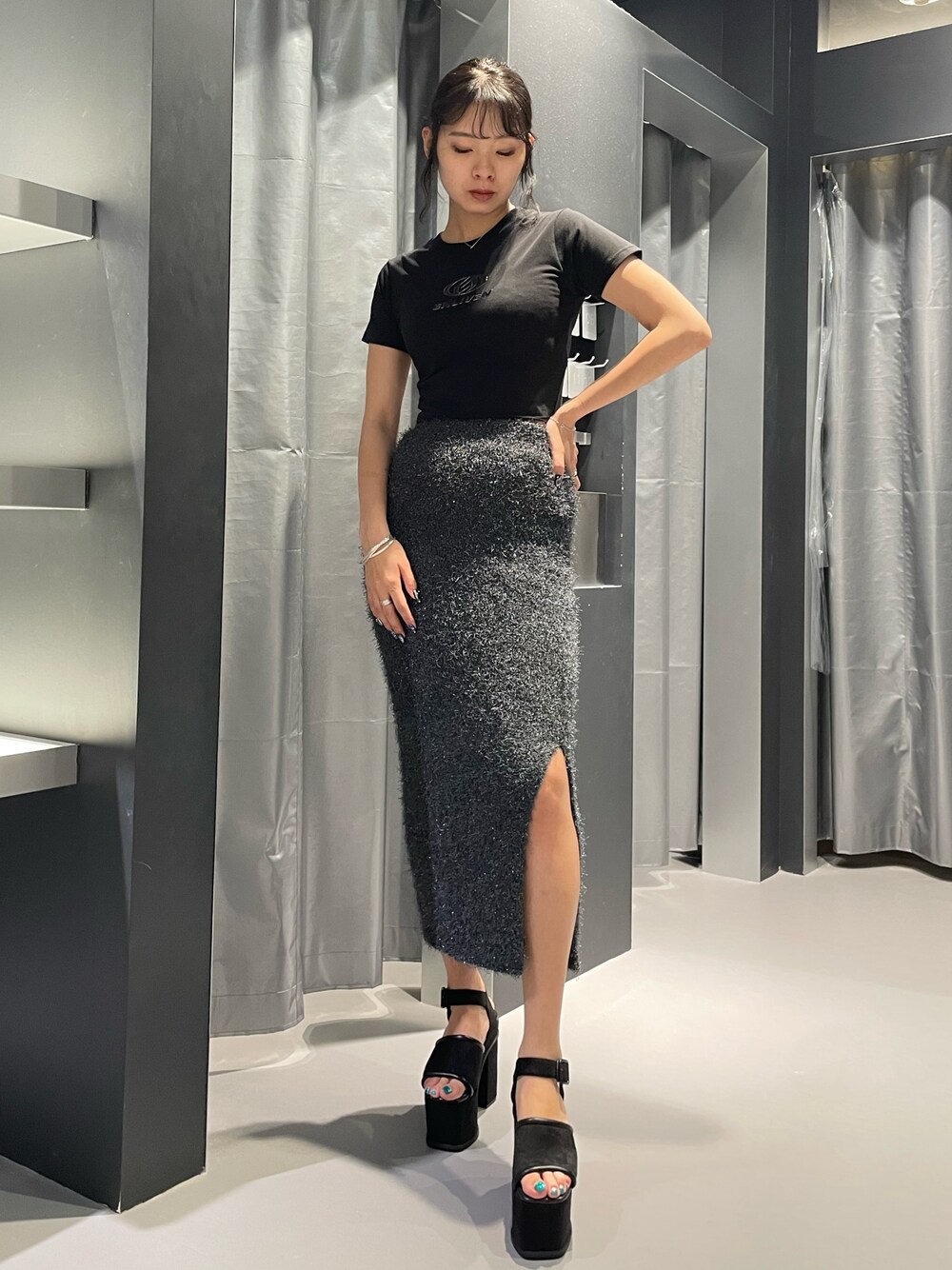 ブラック系のTシャツ/カットソー、グレー系のスカート、ブラック系のサンダルを着用したレディースの夏コーディネートの1枚目の写真