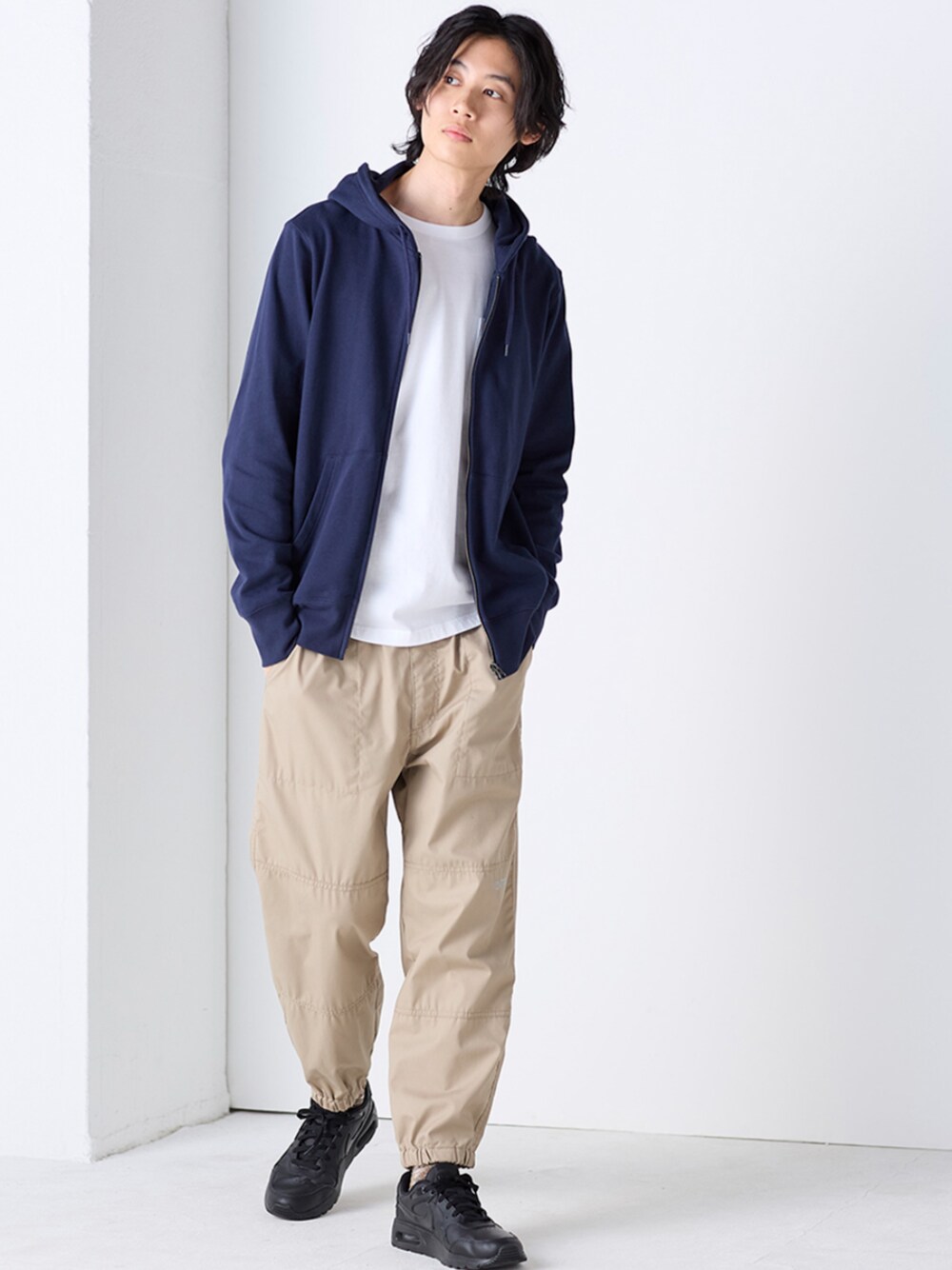 ブルー系のパーカー、ホワイト系のTシャツ/カットソー、ベージュ系のパンツを着用したメンズの秋コーディネートの1枚目の写真