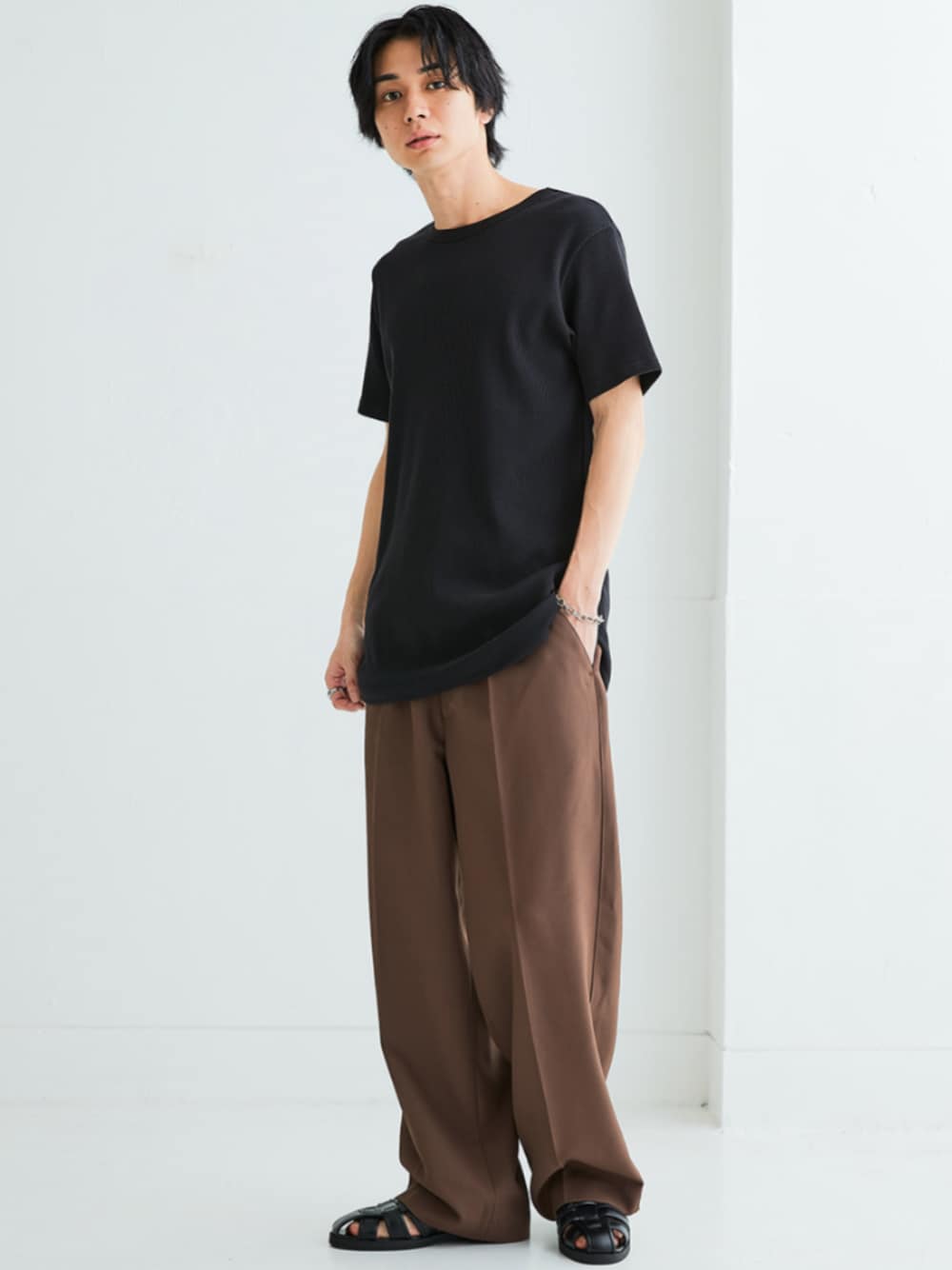 ブラック系のサンダル、ブラウン系のパンツ、ブラック系のTシャツ/カットソーを着用したメンズの春コーディネートの1枚目の写真