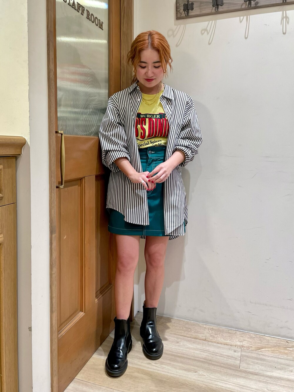 ブラック系のシャツ/ブラウス、イエロー系のTシャツ/カットソー、グリーン系のスカートを着用したレディースの春コーディネートの1枚目の写真