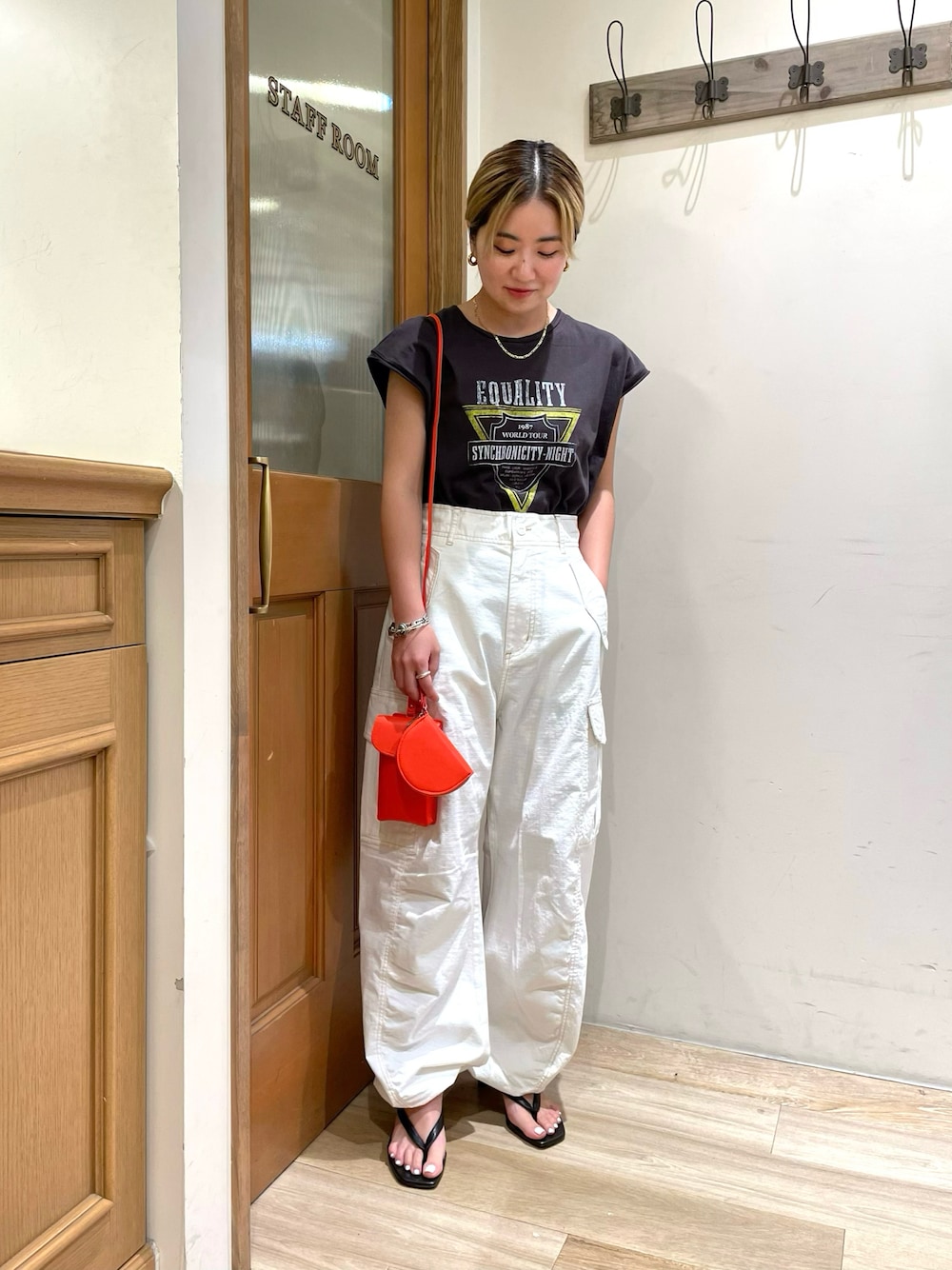 グレー系のTシャツ/カットソー、ホワイト系のカーゴパンツ、ブラック系のサンダルを着用したレディースの秋コーディネートの1枚目の写真