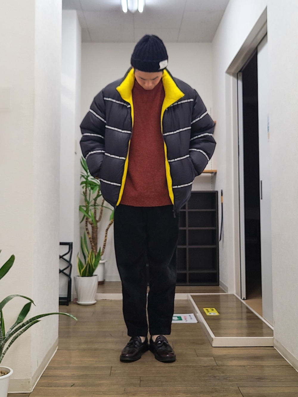 ブラウン系のドレスシューズ、ブラック系のその他パンツ、ブラック系のダウンジャケット/コートを着用したメンズの冬コーディネートの1枚目の写真