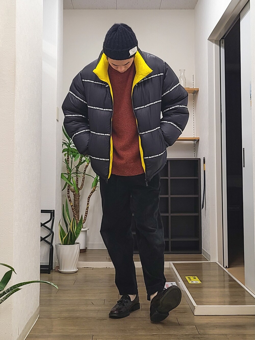 ブラウン系のドレスシューズ、ブラック系のその他パンツ、ブラック系のダウンジャケット/コートを着用したメンズの冬コーディネートの2枚目の写真