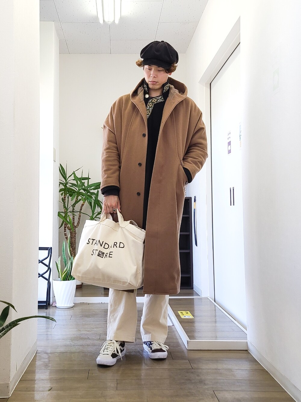 ブラック系のトップス、ブラウン系のスニーカー、ホワイト系のその他パンツを着用したメンズの冬コーディネートの2枚目の写真