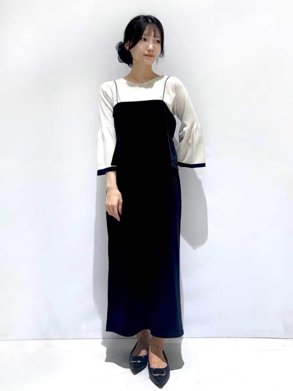 ブラック系のシャツ/ブラウス、グレー系のニット/セーター、ブラック系のスカートを着用したレディースの秋コーディネートの1枚目の写真