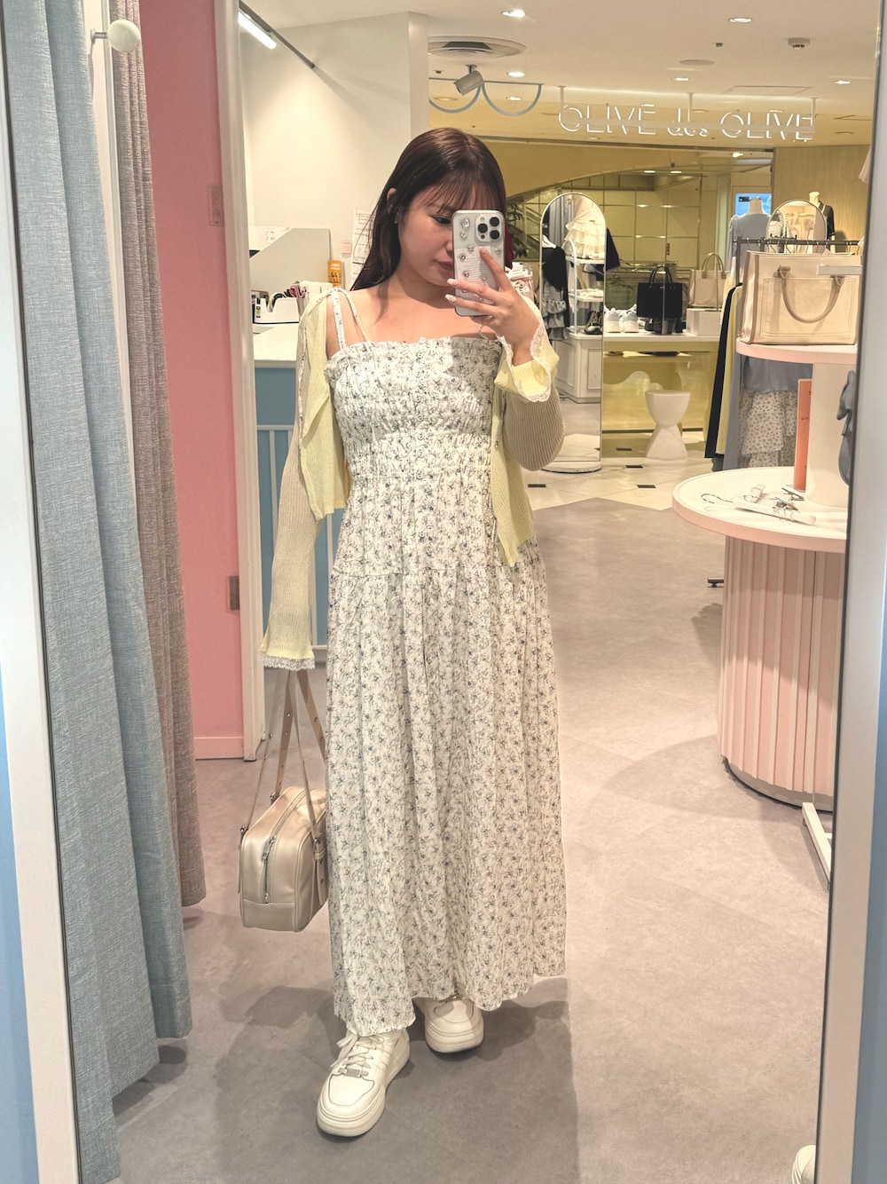 イエロー系のカーディガン/ボレロ、ホワイト系のワンピースを着用したレディースの春コーディネートの1枚目の写真