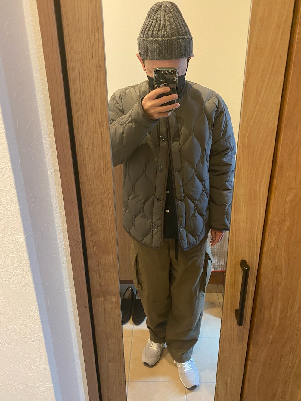 グレー系のスニーカー、グレー系のダウンジャケット/コート、ブラック系のベルトを着用したメンズの冬コーディネートの1枚目の写真