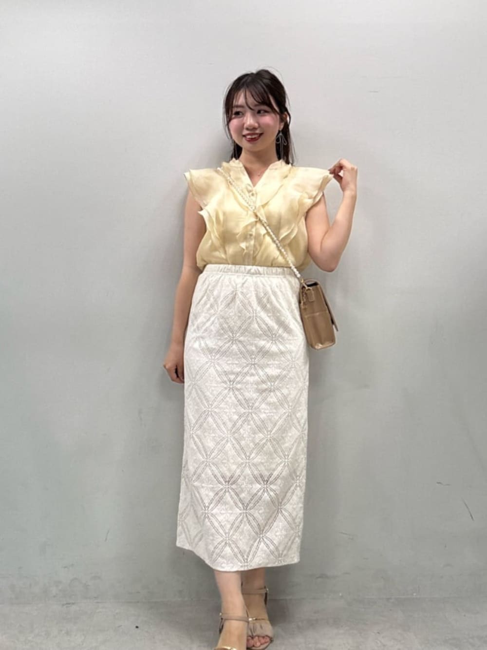 ベージュ系のシャツ/ブラウス、ホワイト系のスカートを着用したレディースの夏コーディネートの1枚目の写真