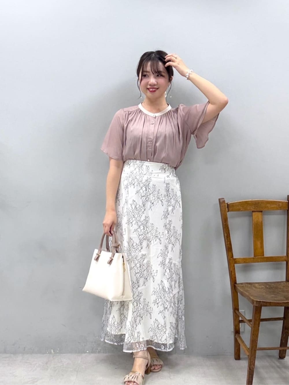 ホワイト系のスカート、ピンク系のシャツ/ブラウスを着用したレディースの夏コーディネートの1枚目の写真