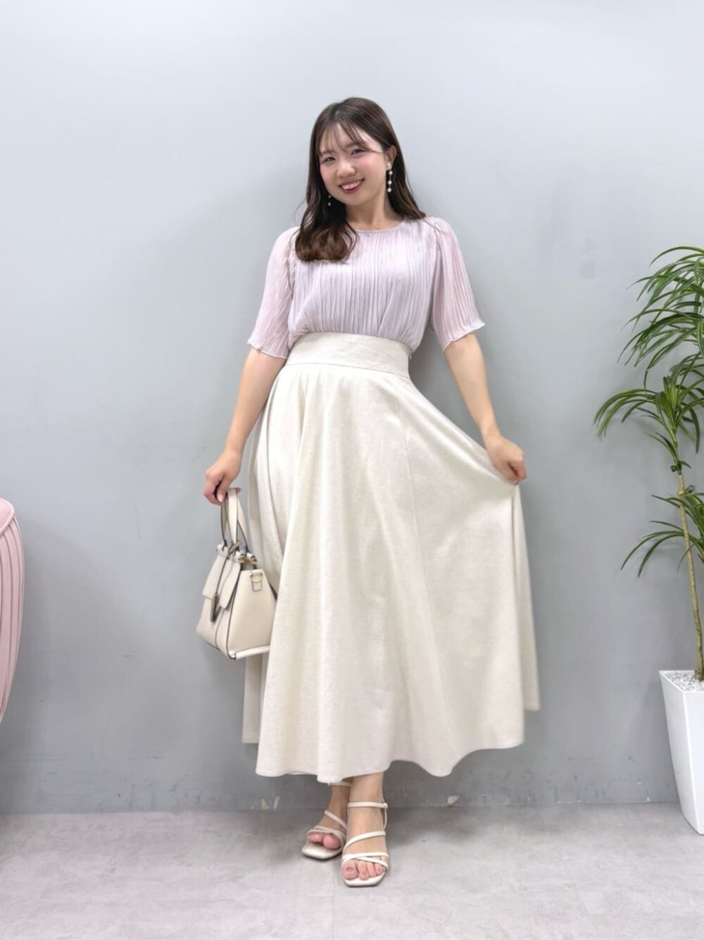 ホワイト系のショルダーバッグ、ベージュ系のスカート、ピンク系のシャツ/ブラウスを着用したレディースの夏コーディネートの1枚目の写真