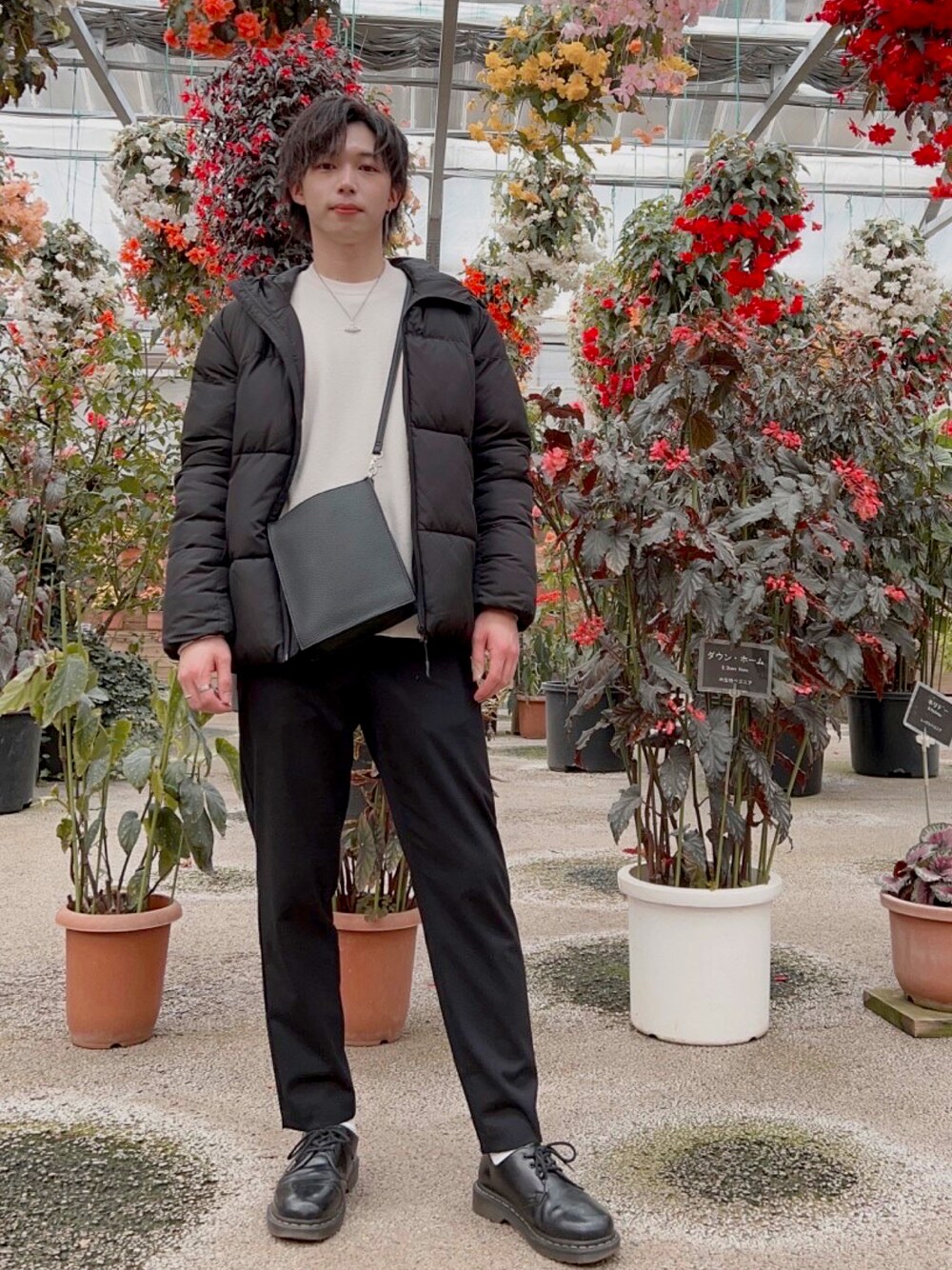 ブラック系のダウンジャケット/コート、ホワイト系のニット/セーター、ブラック系のスラックスを着用したメンズの冬コーディネートの1枚目の写真