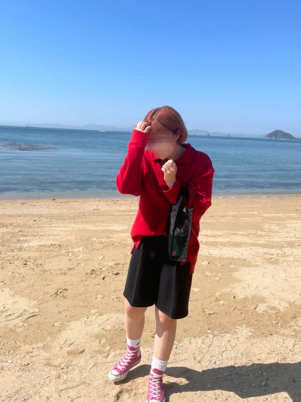 レッド系のトップス、ピンク系のスニーカー、ブラック系のスラックスを着用したレディースの春コーディネートの1枚目の写真