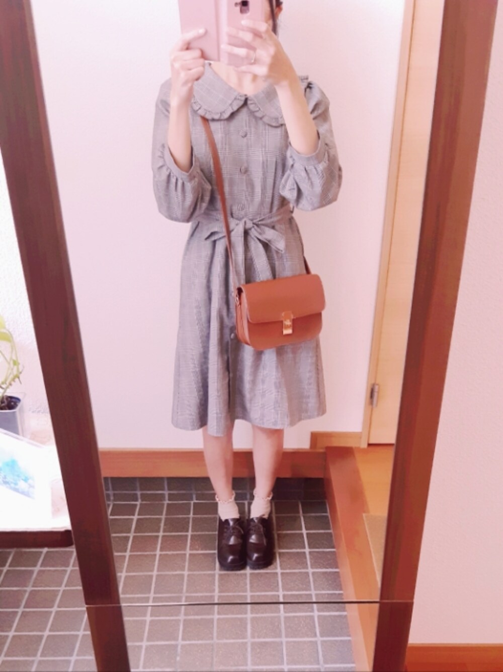 ブラウン系のローファー、グレー系のワンピース、ブラウン系のショルダーバッグを着用したレディースの秋コーディネートの1枚目の写真