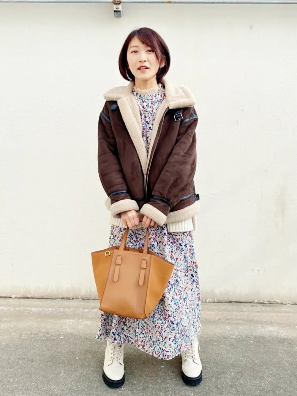 グリーン系のワンピース、ブラウン系のショルダーバッグ、ブラウン系のブルゾンを着用したレディースの冬コーディネートの3枚目の写真