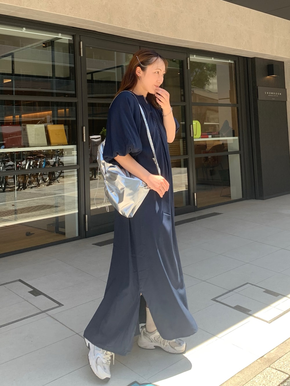 ブルー系のワンピース、シルバー系のバックパック/リュック、シルバー系のスニーカーを着用したレディースの春コーディネートの1枚目の写真