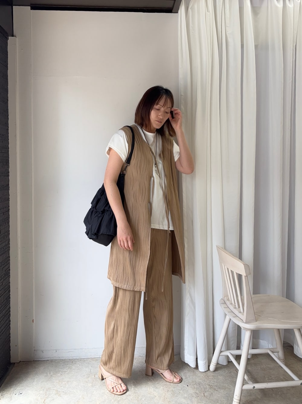 ベージュ系のサロペット/オーバーオール、ホワイト系のTシャツ/カットソー、ブラック系のショルダーバッグを着用したレディースの夏コーディネートの1枚目の写真
