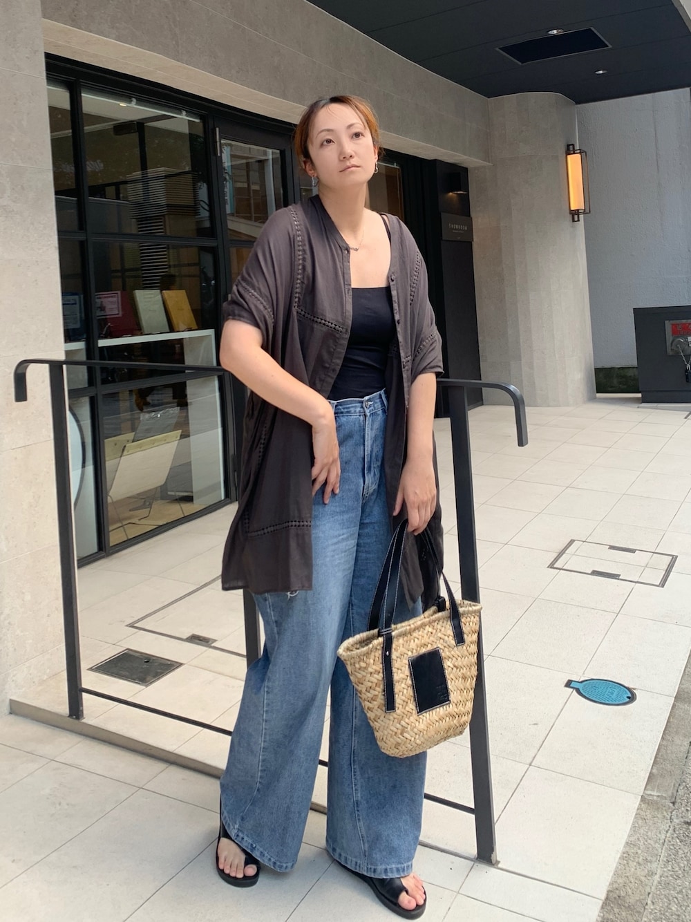 グリーン系のシャツ/ブラウス、ブラック系のかごバッグ、ブルー系のデニムパンツを着用したレディースの夏コーディネートの1枚目の写真