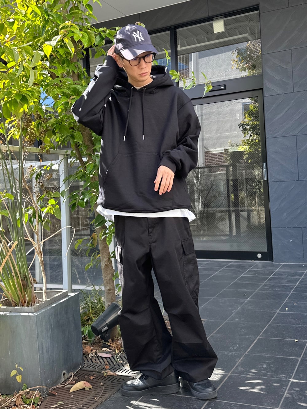 ブラック系のパーカー、ホワイト系のTシャツ/カットソー、ブラック系のカーゴパンツを着用したメンズの冬コーディネートの1枚目の写真