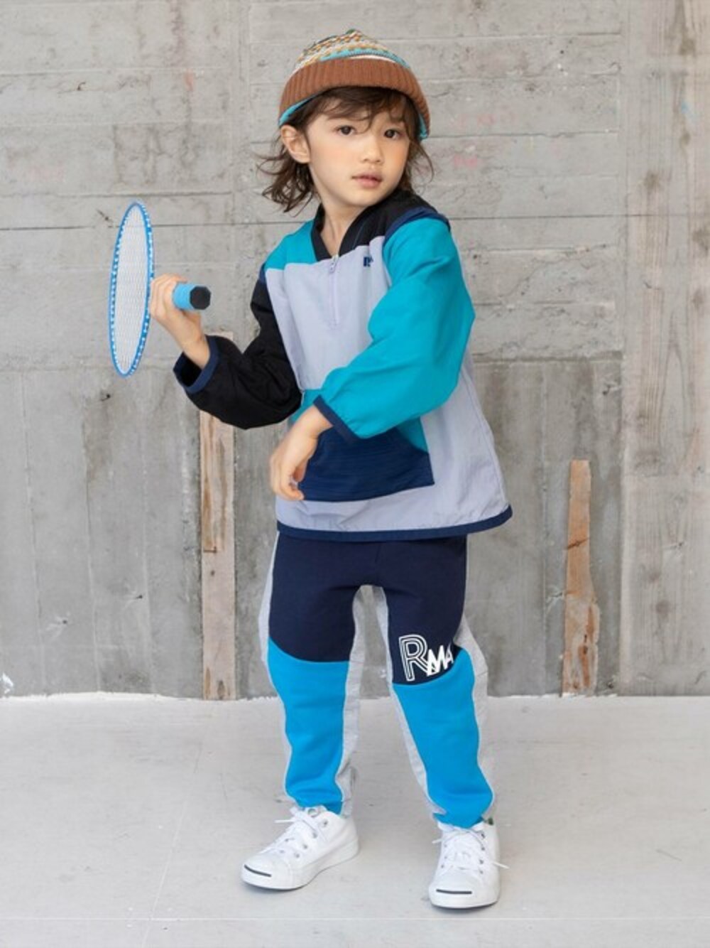グレー系のナイロンジャケット、ブルー系のその他パンツ、グリーン系のTシャツ/カットソーを着用したキッズの春コーディネートの1枚目の写真