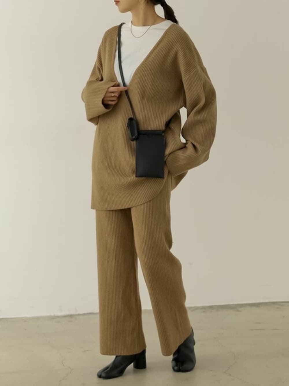 ベージュ系のニット/セーター、ホワイト系のTシャツ/カットソー、ベージュ系のその他パンツを着用したレディースの冬コーディネートの1枚目の写真