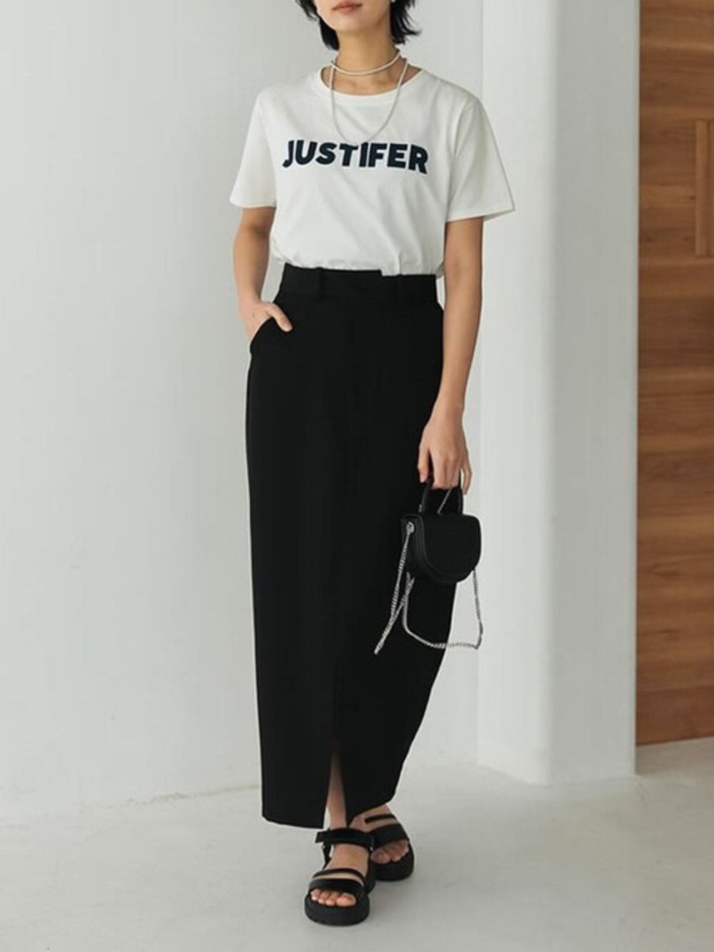 ホワイト系のTシャツ/カットソー、ブラック系のスカート、ブラック系のサンダルを着用したレディースの冬コーディネートの1枚目の写真