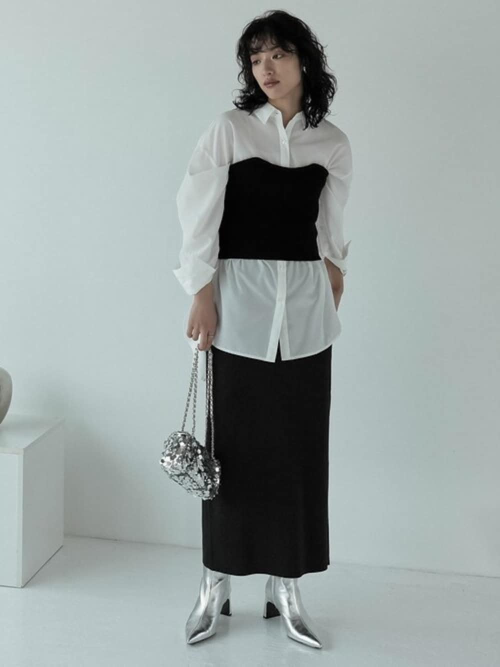 ブラック系のスカート、ホワイト系のシャツ/ブラウス、ブラック系のチューブトップを着用したレディースの秋コーディネートの1枚目の写真